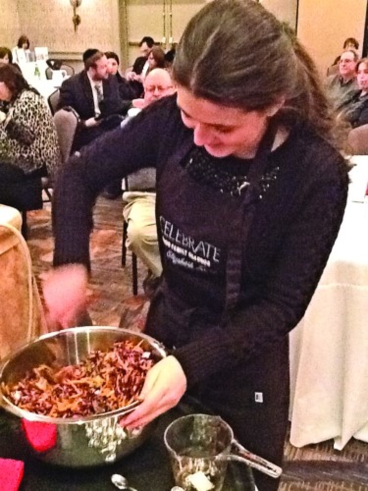Sarah Kurtz helps her mother at a cooking demonstration during the PHDS Cooking for A Cause fundraiser. 